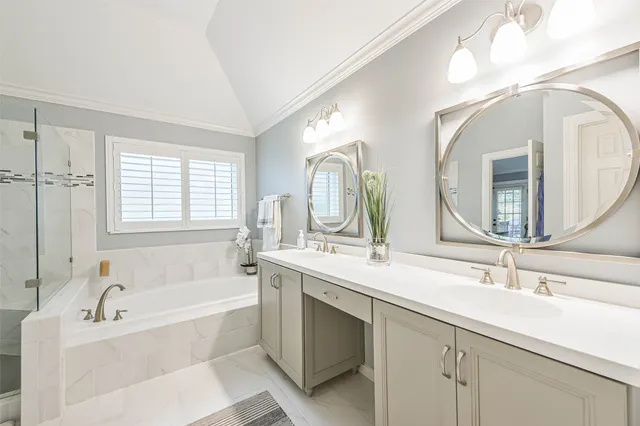 a bathroom with a tub a double vanity sink and mirror