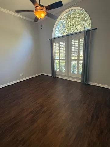 an empty room with a window and wooden floor