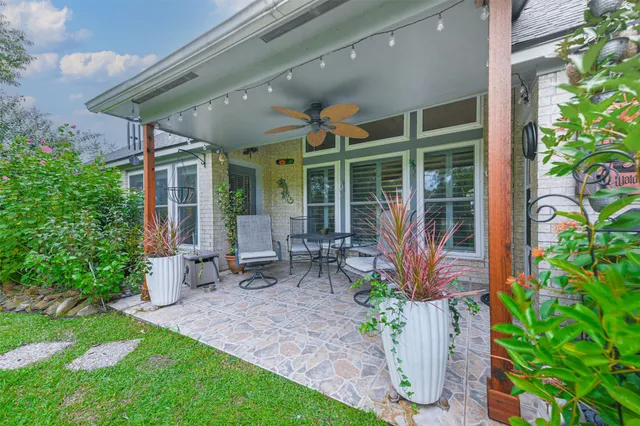 a garden with chairs and a potted plant