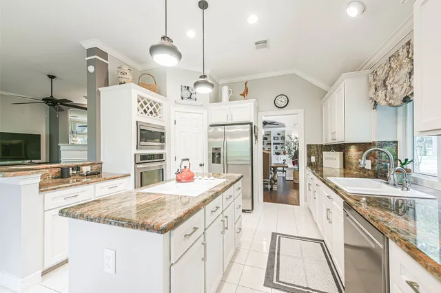 a kitchen with stainless steel appliances granite countertop a sink and cabinets