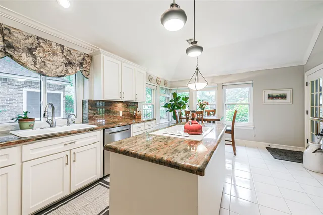 a kitchen with granite countertop a sink a stove cabinets and counter space