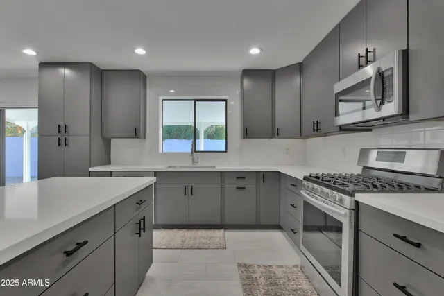 a kitchen with a sink stove and cabinets