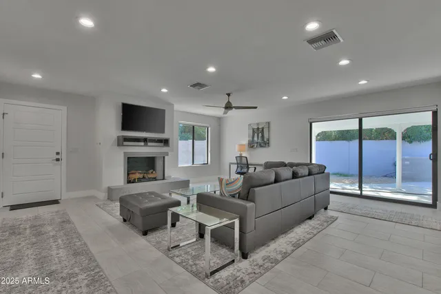 a living room with furniture a fireplace and a flat screen tv