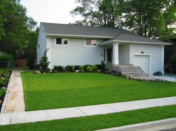 702 Fishermans Road Baldwin, NY 11510 - Photo 1 of 1 a front view of a house with a garden