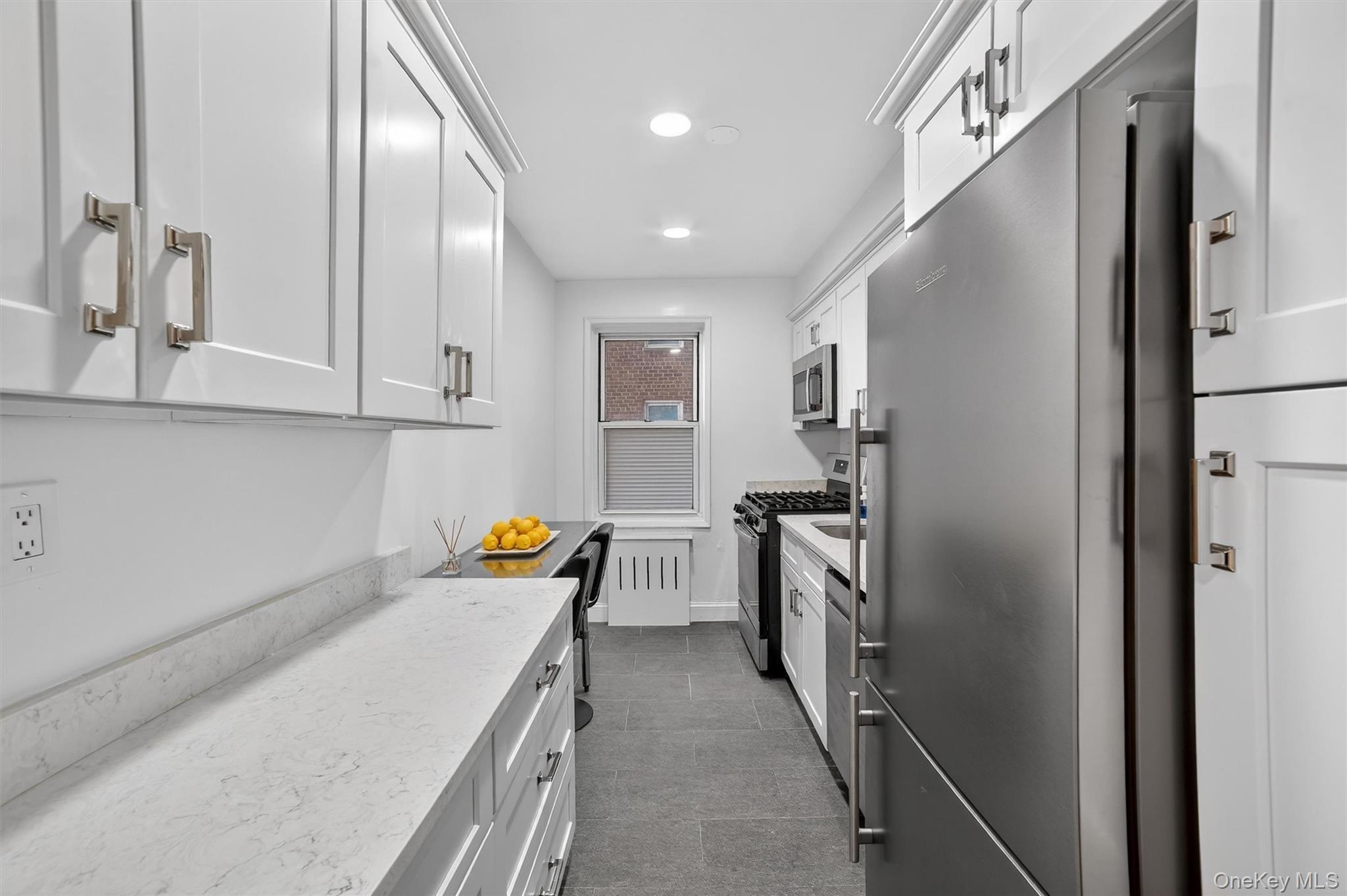 60 Locust Avenue, Unit 214A New Rochelle, NY 10801 - Photo 12 of 20 Kitchen featuring stainless steel appliances, white cabinets, recessed lighting, and light stone countertops