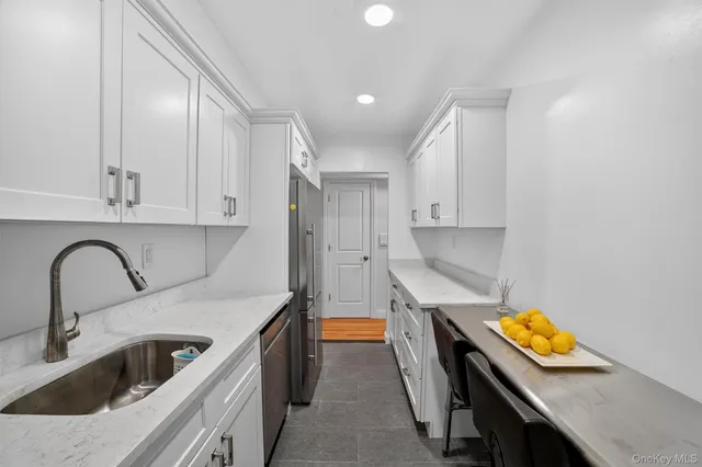 a kitchen with stainless steel appliances a stove a sink and a refrigerator