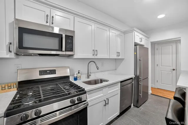 a kitchen with stainless steel appliances granite countertop a stove microwave and sink