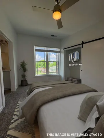 a bedroom with a bed and a large window