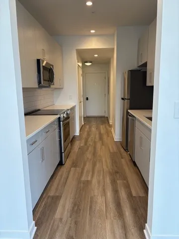 a large kitchen with a stove top oven a sink a microwave and refrigerator