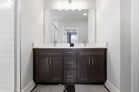 a bathroom with a double vanity sink and a mirror