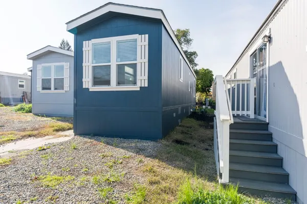 a view of a house with wooden fence and two windows