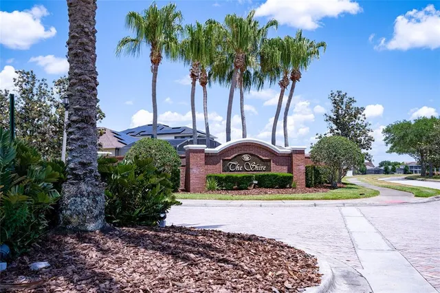 a front view of a house with garden and trees