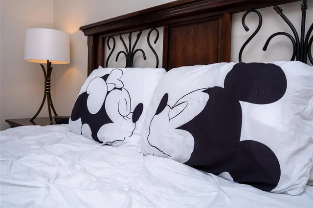 a bedroom with two bed and a lamp on dresser