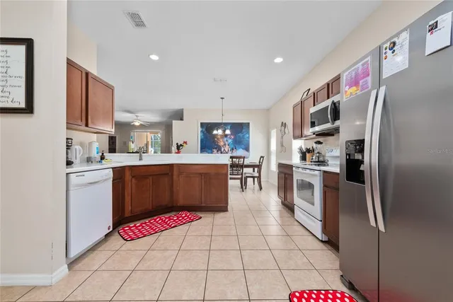 a kitchen with stainless steel appliances granite countertop a sink dishwasher a refrigerator and a microwave oven