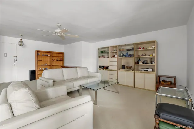 a living room with furniture a rug and white walls