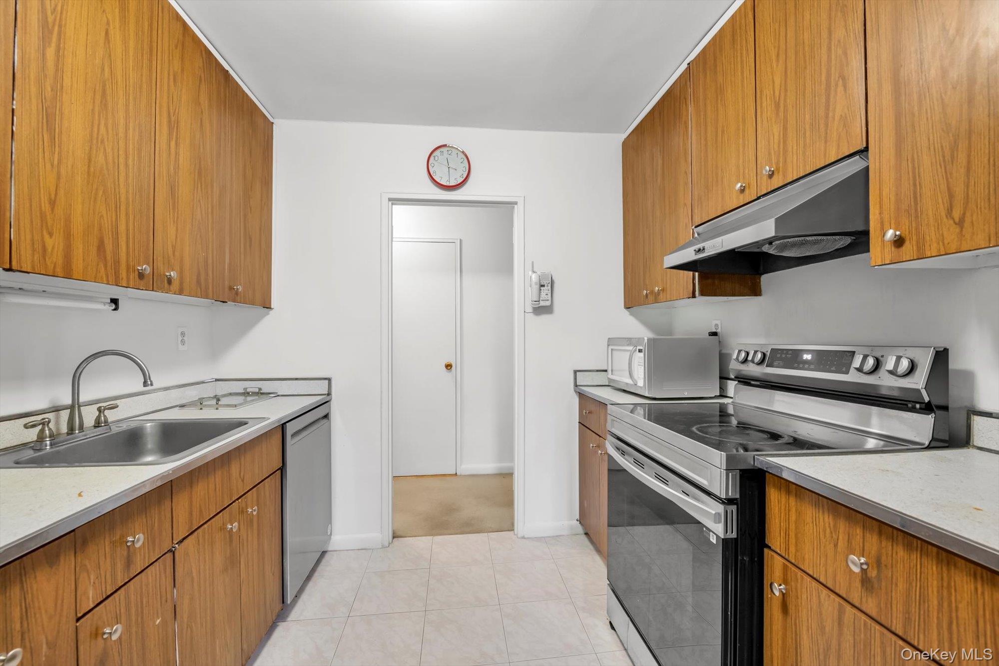 25 Chapel Place, Unit 3N Great Neck, NY 11021 - Photo 10 of 23 a kitchen with stainless steel appliances granite countertop a sink stove and refrigerator