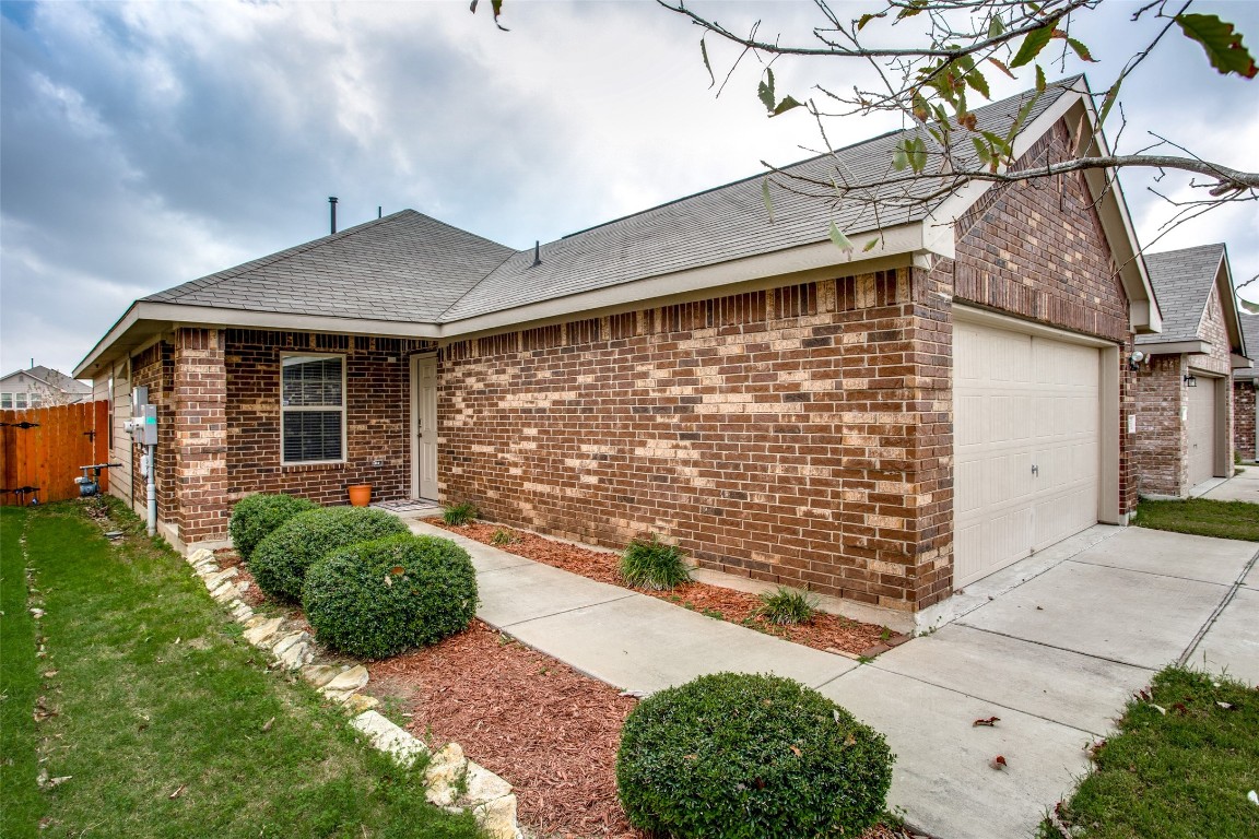 Ranch-style house featuring a garage and a front lawn