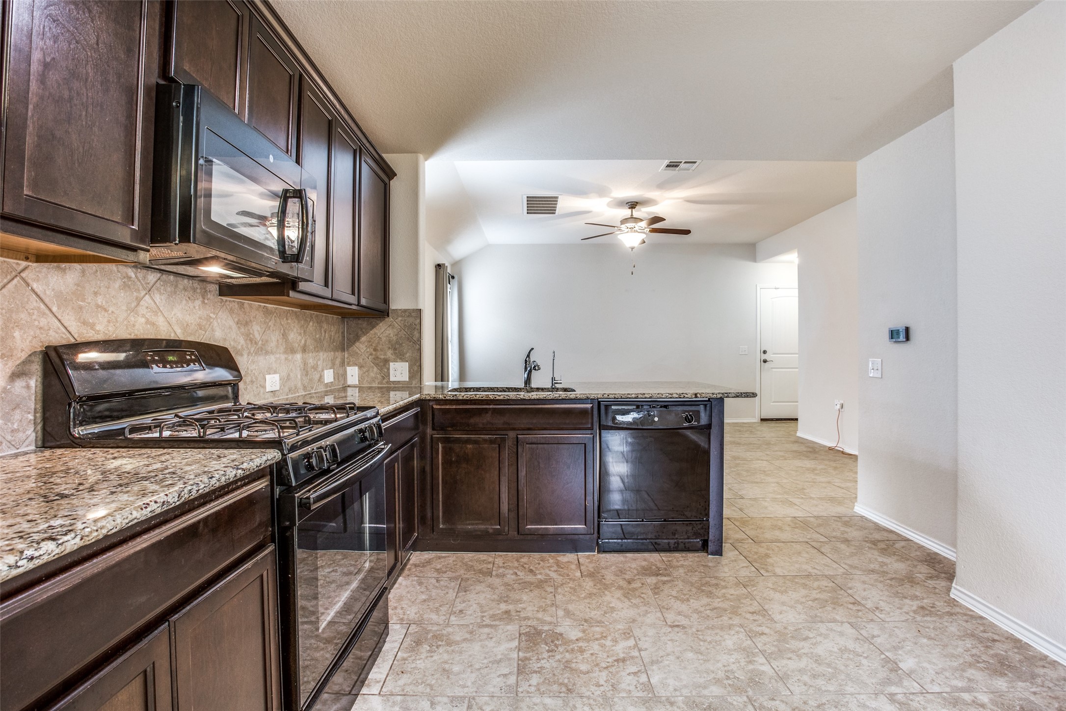 3605 Alpine Autumn Drive Austin, TX 78744 - Photo 11 of 25 a kitchen with a stove and a microwave