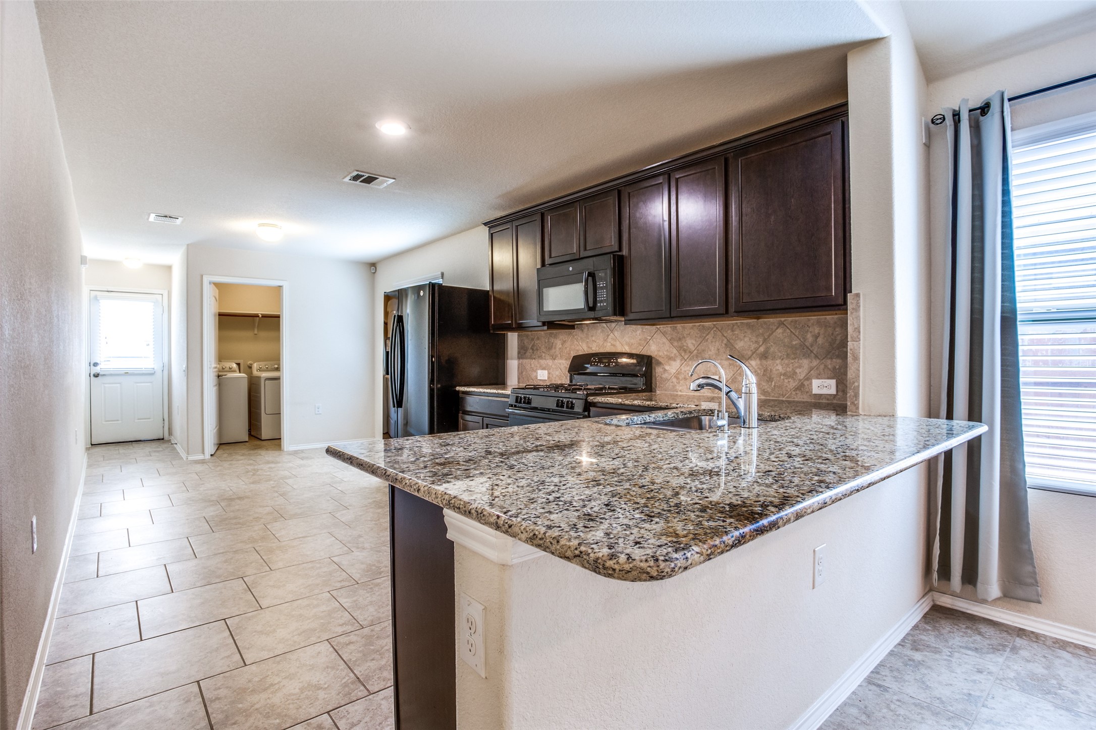 3605 Alpine Autumn Drive Austin, TX 78744 - Photo 8 of 25 a kitchen with stainless steel appliances granite countertop a sink stove and refrigerator