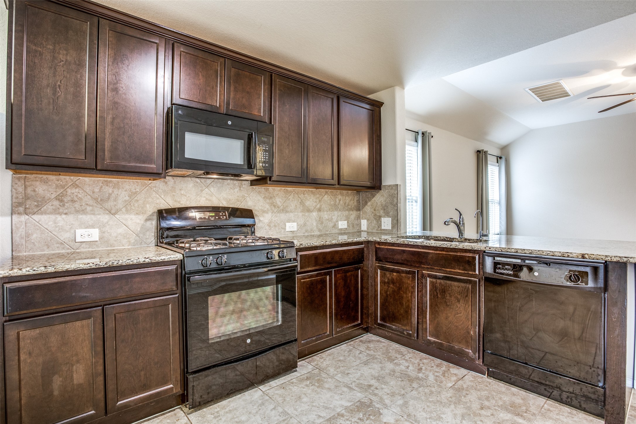 3605 Alpine Autumn Drive Austin, TX 78744 - Photo 10 of 25 a kitchen with stainless steel appliances granite countertop a sink stove and microwave