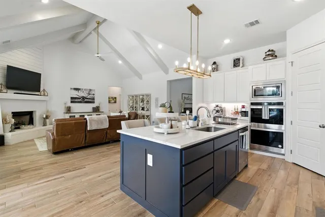 a large kitchen with stainless steel appliances a sink stove and refrigerator