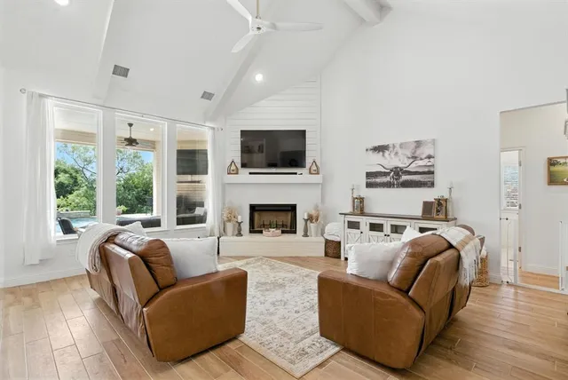 a living room with furniture a flat screen tv and a fireplace