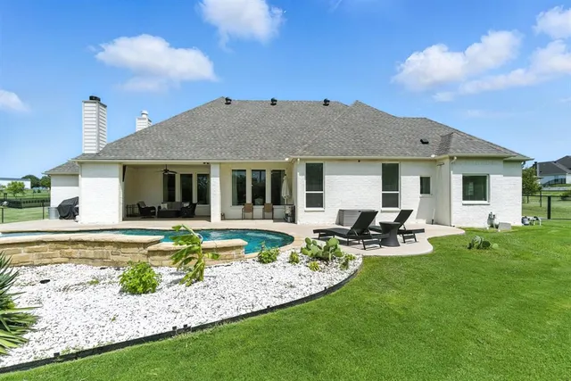a view of a house with backyard sitting area and garden