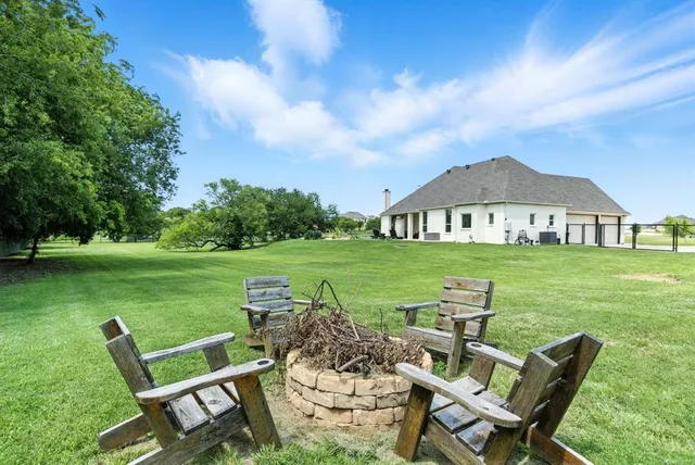 a view of a wooden chairs and table in the garden