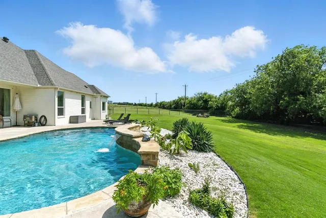 a view of a house with backyard and a sitting area