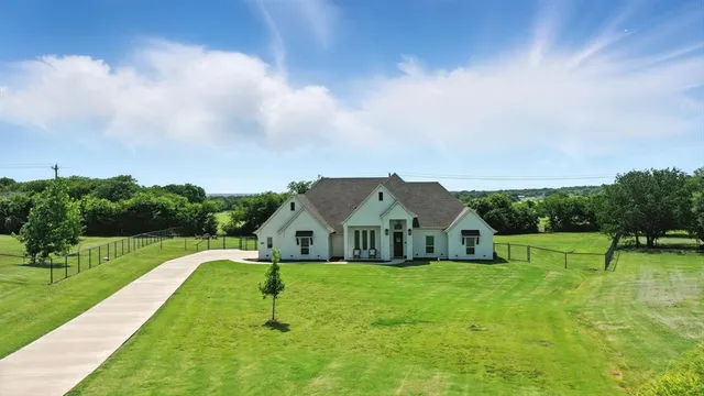 a house with green field in front of it