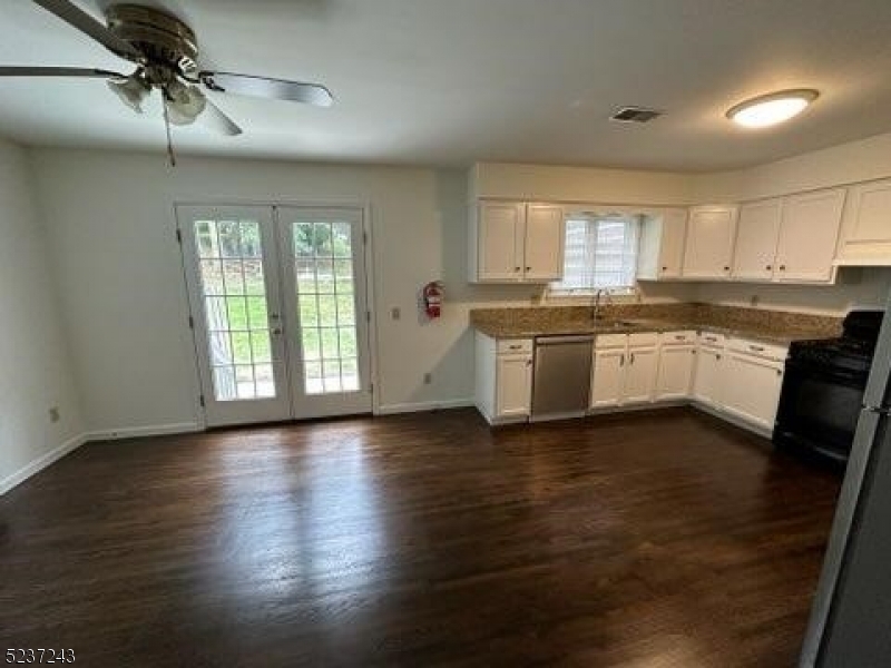 2 Magnolia Court, Unit 2A Madison, NJ 07940 - Photo 3 of 16 a large kitchen with stainless steel appliances granite countertop a stove top oven a sink a dishwasher with wooden floor and cabinets