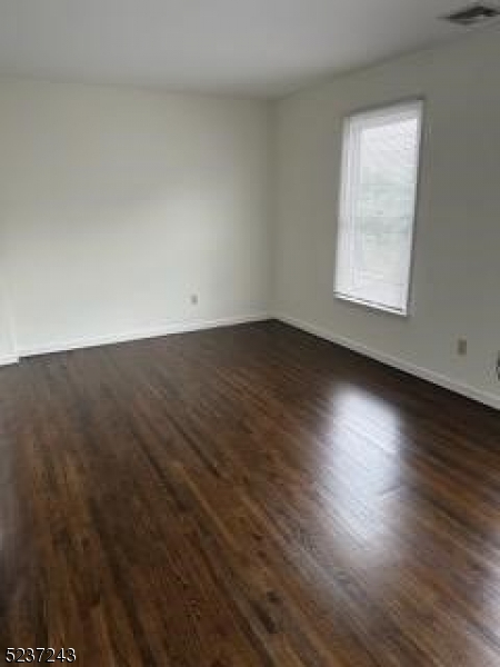 2 Magnolia Court, Unit 2A Madison, NJ 07940 - Photo 5 of 16 an empty room with wooden floor and windows