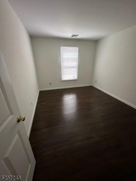 2 Magnolia Court, Unit 2A Madison, NJ 07940 - Photo 7 of 16 an empty room with wooden floor and windows