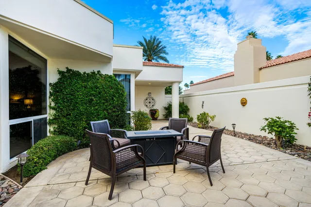 a view of a patio with table and chairs potted plants and wooden fence
