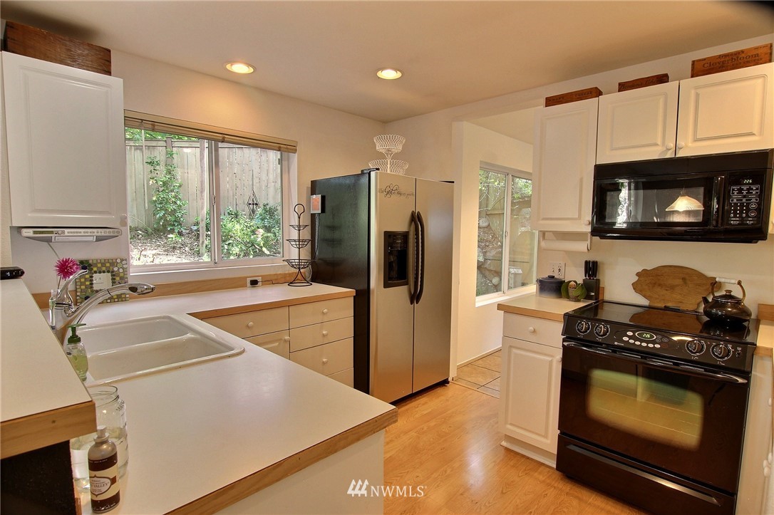 26412 231st Place Southeast Maple Valley, WA 98038 - Photo 5 of 18 a kitchen with granite countertop a stove a sink and a refrigerator
