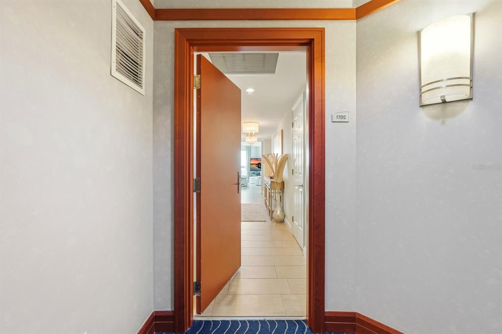 231 Riverside Drive, Unit 1702 Holly Hill, FL 32117 - Photo 4 of 74 a view of a hallway with wooden floor and a living room