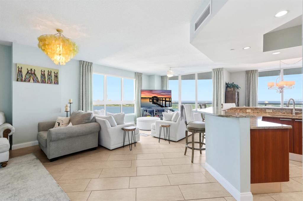 231 Riverside Drive, Unit 1702 Holly Hill, FL 32117 - Photo 8 of 74 a living room with couches and kitchen view with wooden floor