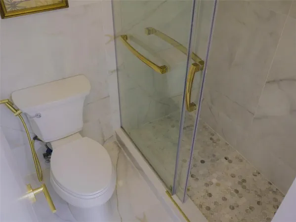 a white toilet sitting next to a bath tub