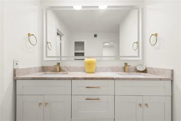 a bathroom with a granite countertop sink and a mirror