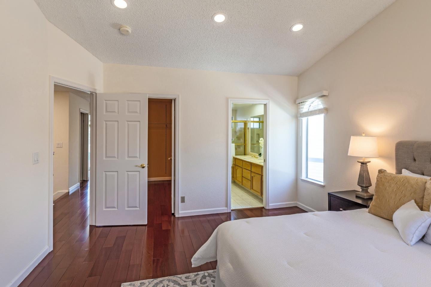 2372 Dubois Street Milpitas, CA 95035 - Photo 14 of 30 a bedroom with a bed and a table with wooden floor