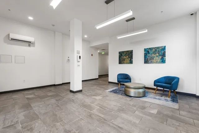 a view of a hallway with chairs and a workspace