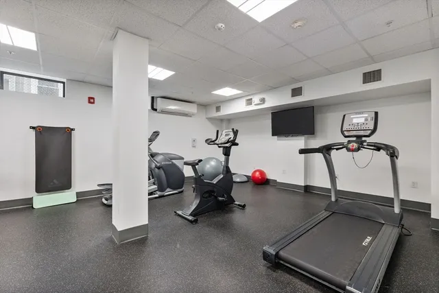 a room with gym equipment and a flat screen tv