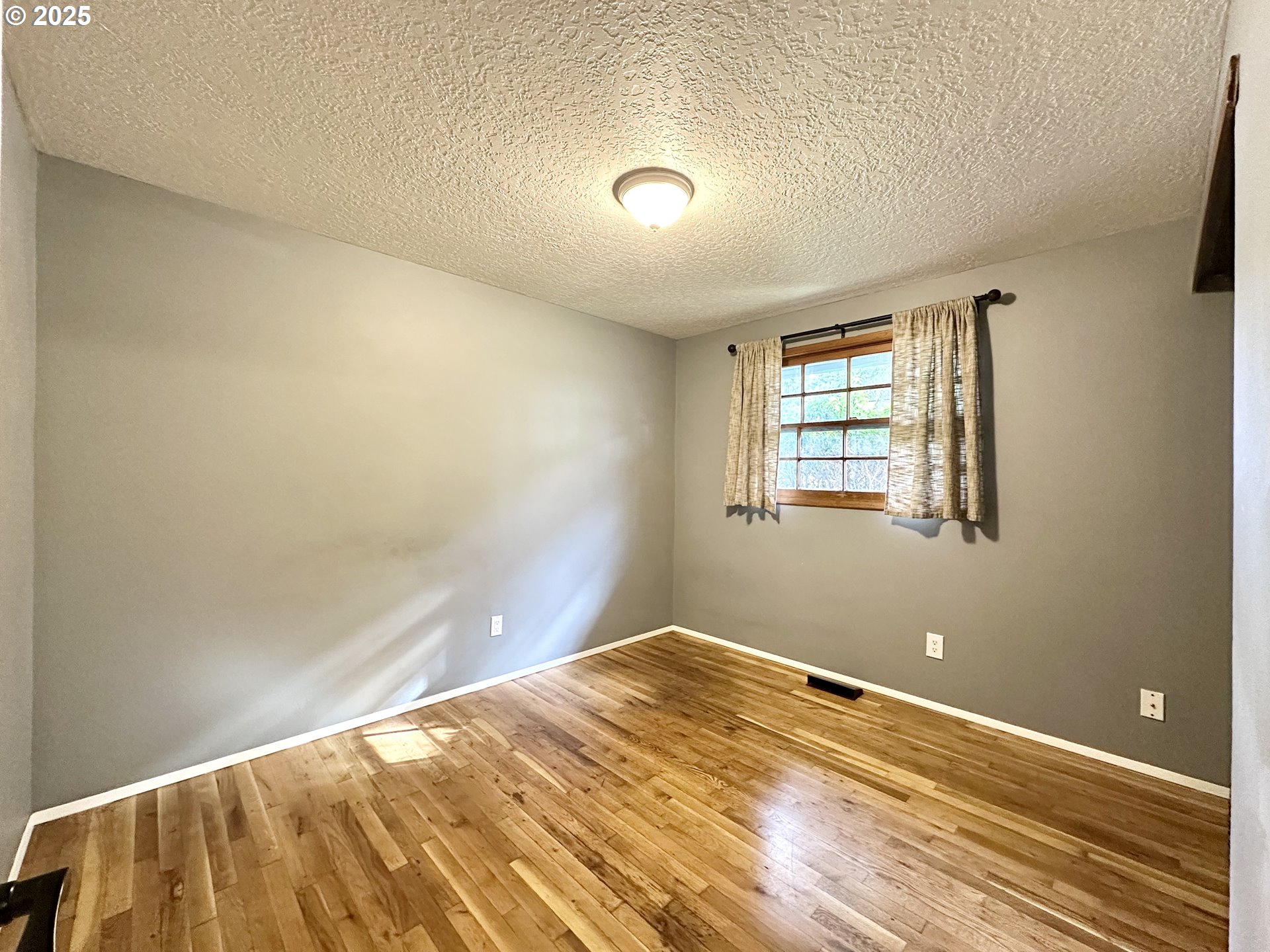 1563 Southeast 11th Street Gresham, OR 97080 - Photo 23 of 30 a view of a big room with wooden floor and windows