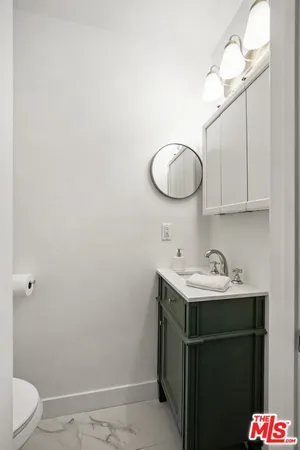 a bathroom with a sink vanity and a toilet