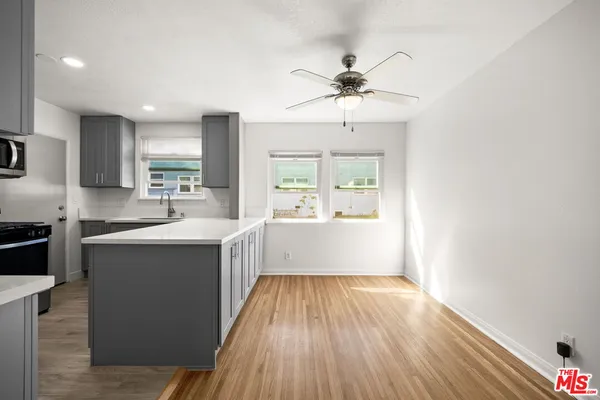 a large kitchen with kitchen island a large counter space and wooden floor