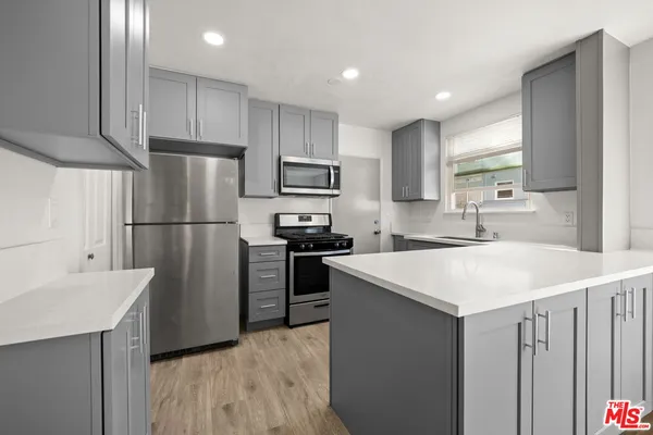 a kitchen with refrigerator cabinets and a sink