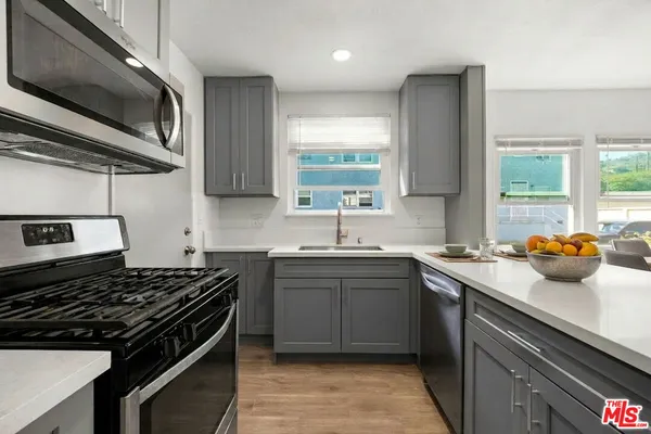 a kitchen with stainless steel appliances a sink stove and cabinets