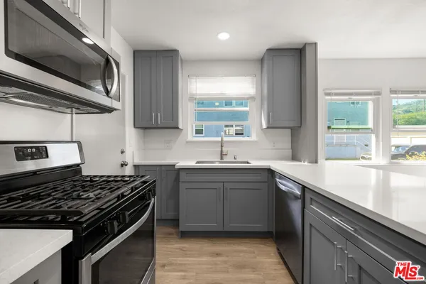 a kitchen with a sink stove top oven and cabinets