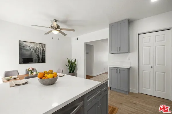 a kitchen with stainless steel appliances a white counter top space cabinets and wooden floor