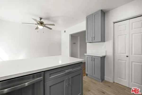a kitchen with a sink dishwasher and a refrigerator with wooden floor